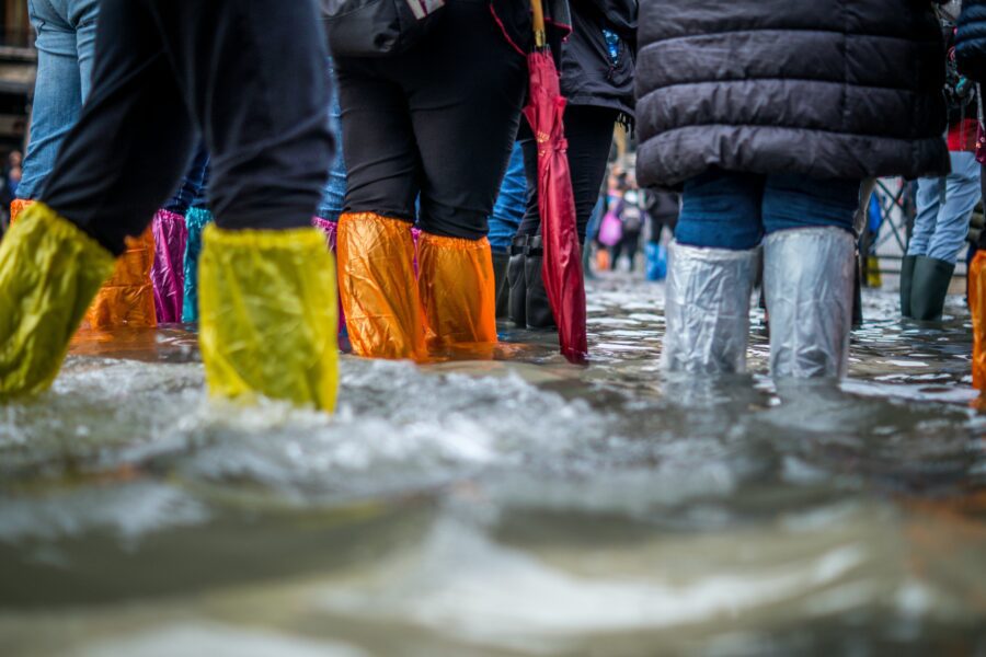 Allerta maltempo: foto di persone che camminano nelle zone colpite da alluvione