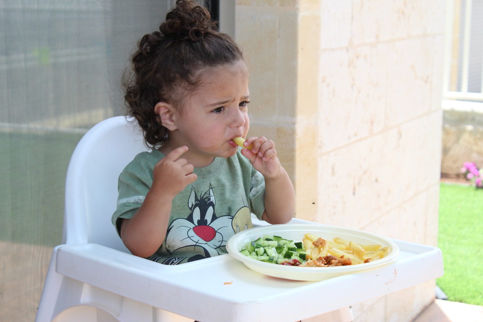 Bambina selettiva davanti a un piatto con diversi alimenti 
