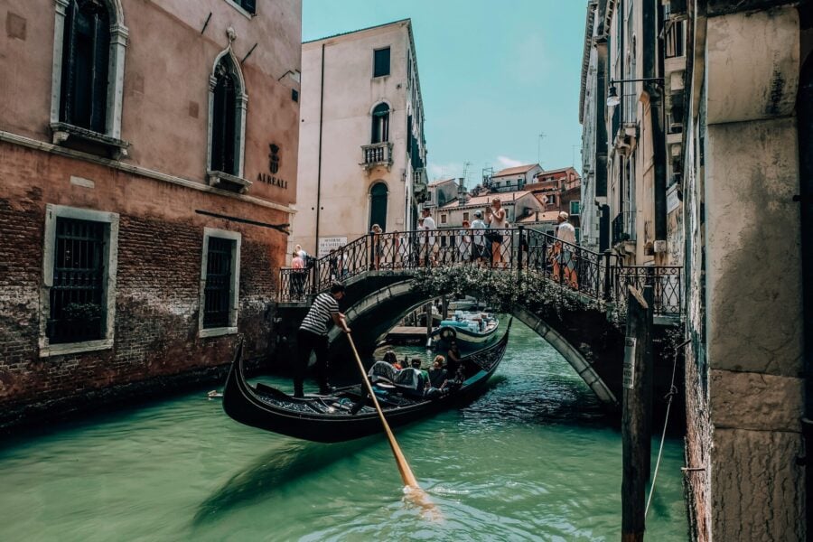 Turismo esperienziale. Turisti su una gondola in un canale di Venezia