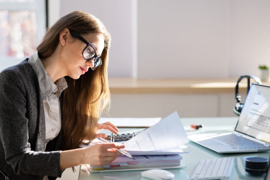Professionista al lavoro su fatture digitali e calcoli aziendali con strumenti per la fatturazione elettronica.