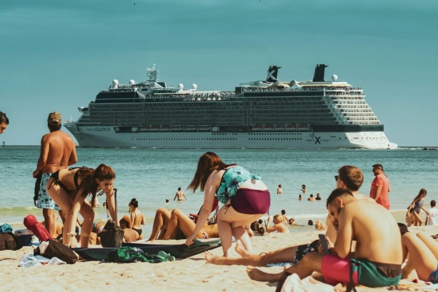 Una nave da crociera di fronte a turisti in spiaggia