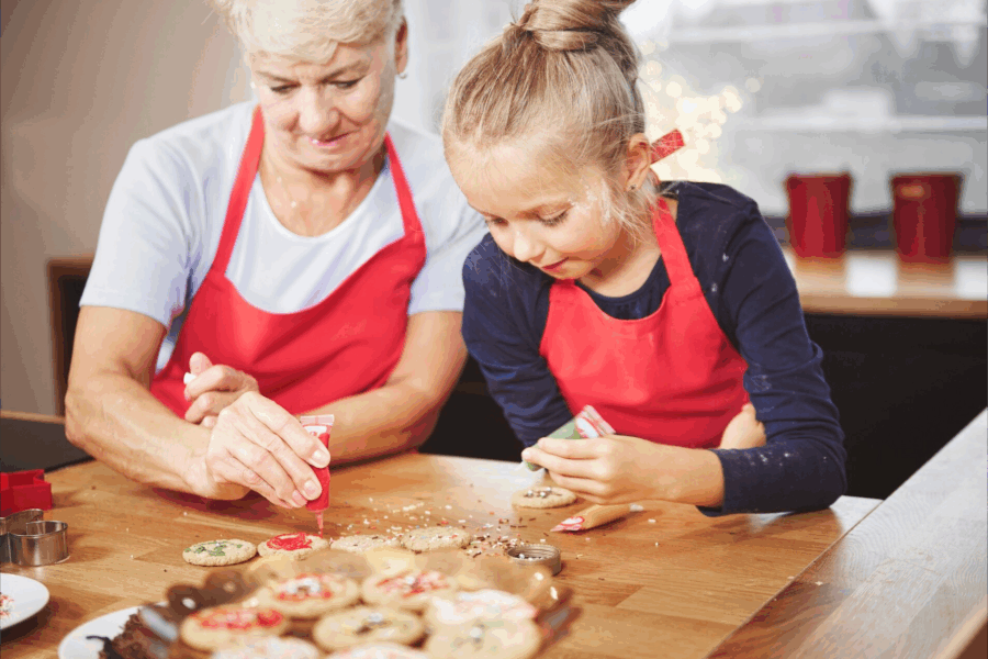 lavori di casa manuali: una signora anziana e una bambina che fanno i biscotti