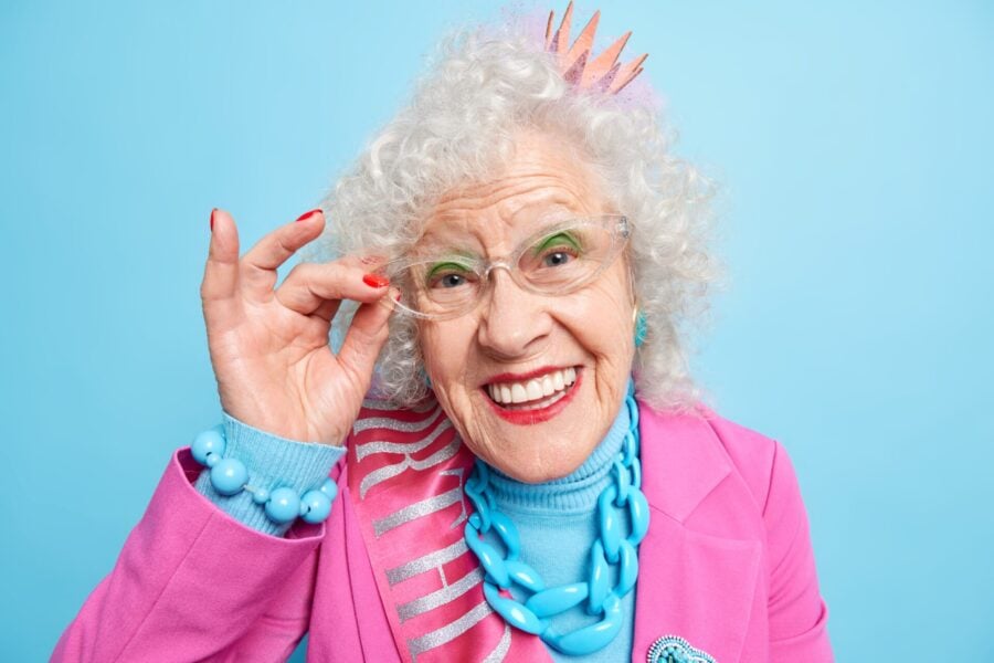 Curare la maculopatia: anziana donna sorridente in abiti sgargianti