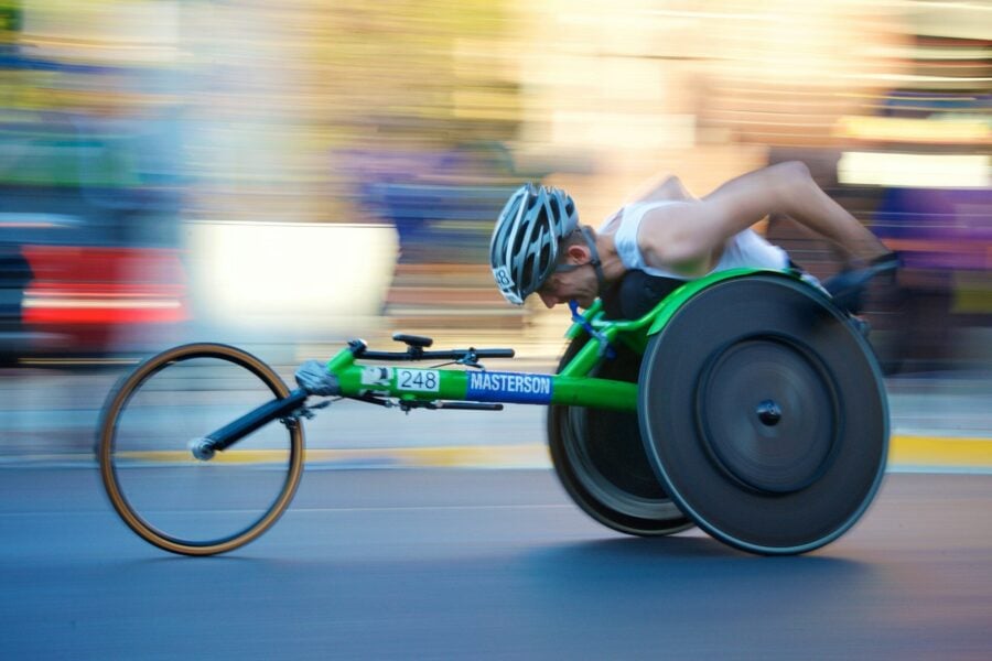 Mondiali atletica paralimpica. Uomo alla guida di una carrozzina da corsa verde durante la Maratona di Chicago del 2017.