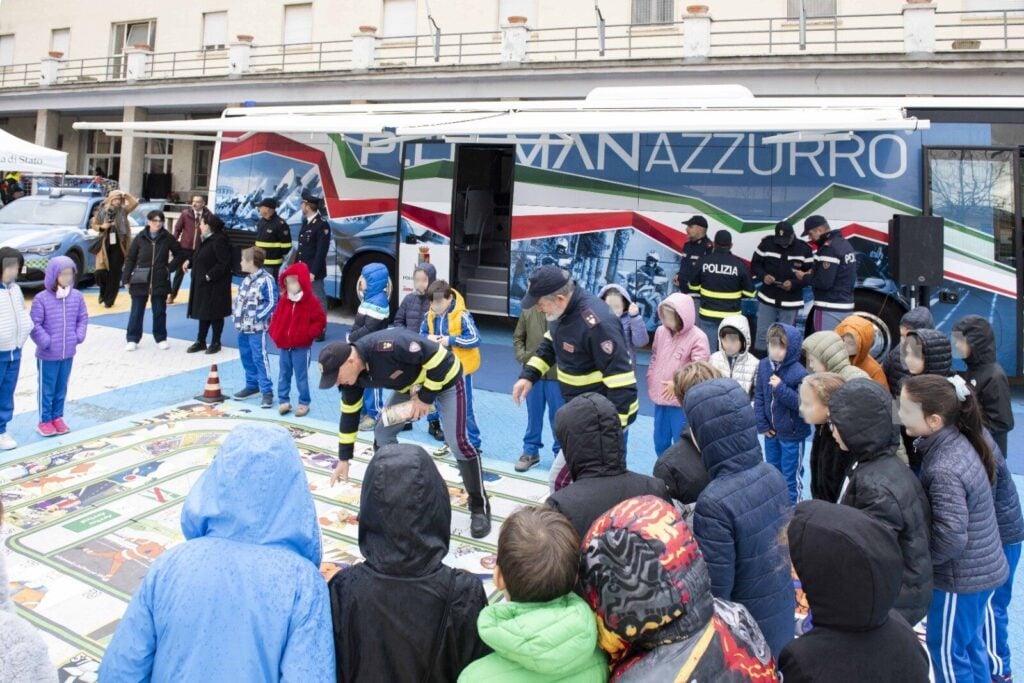 Sicurezza stradale: gruppo di studenti che, giocando, apprende dai poliziotti le regole da osservare (JPG)
