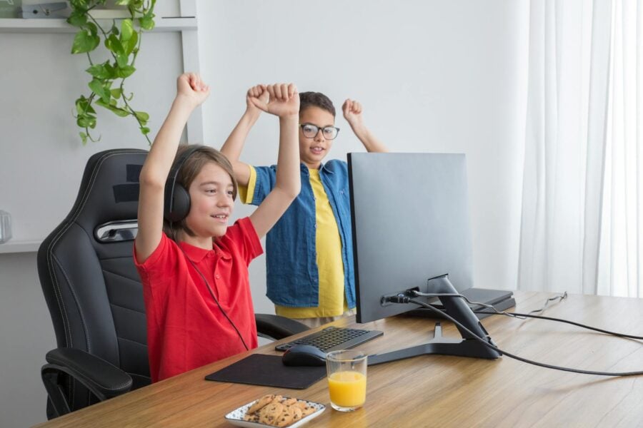 gaming online: due bambini giocano al computer felici