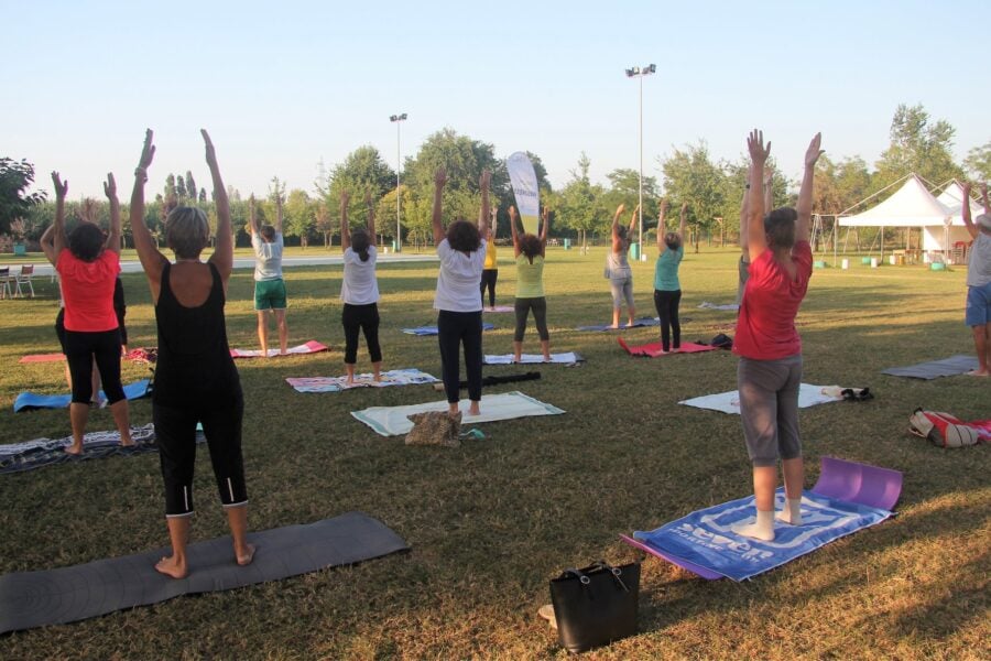 Attivit&agrave; fisica: persone intente a fare pilates in un parco.