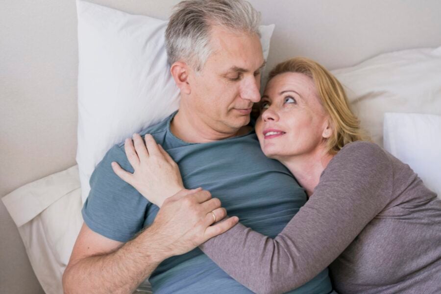 Desiderio sessuale: una donna e un uomo anziani sono abbracciati nel loro letto