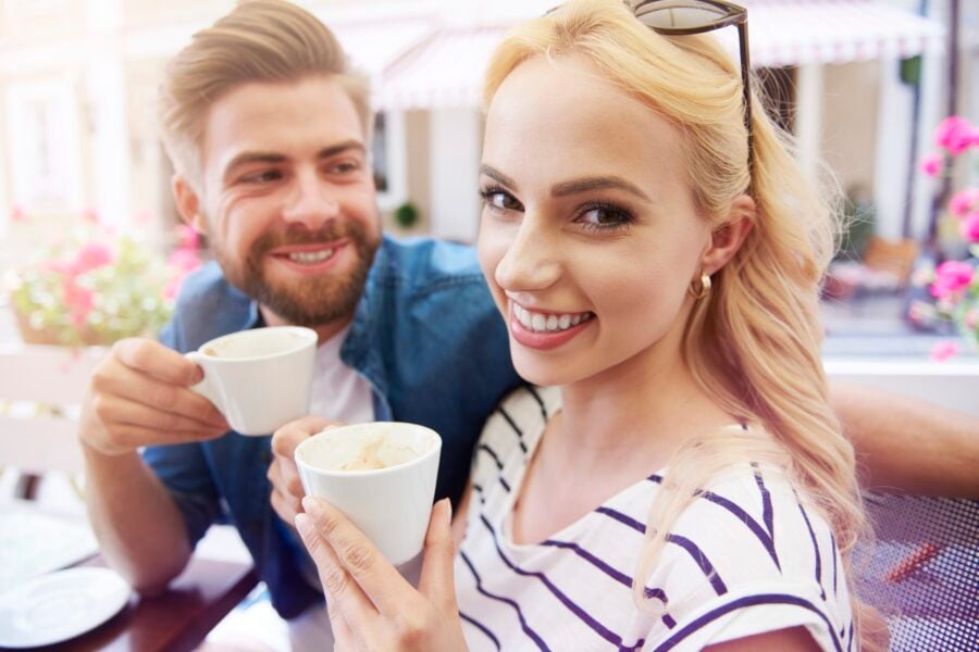 Giovane coppia sorridente mentre beve un caffè